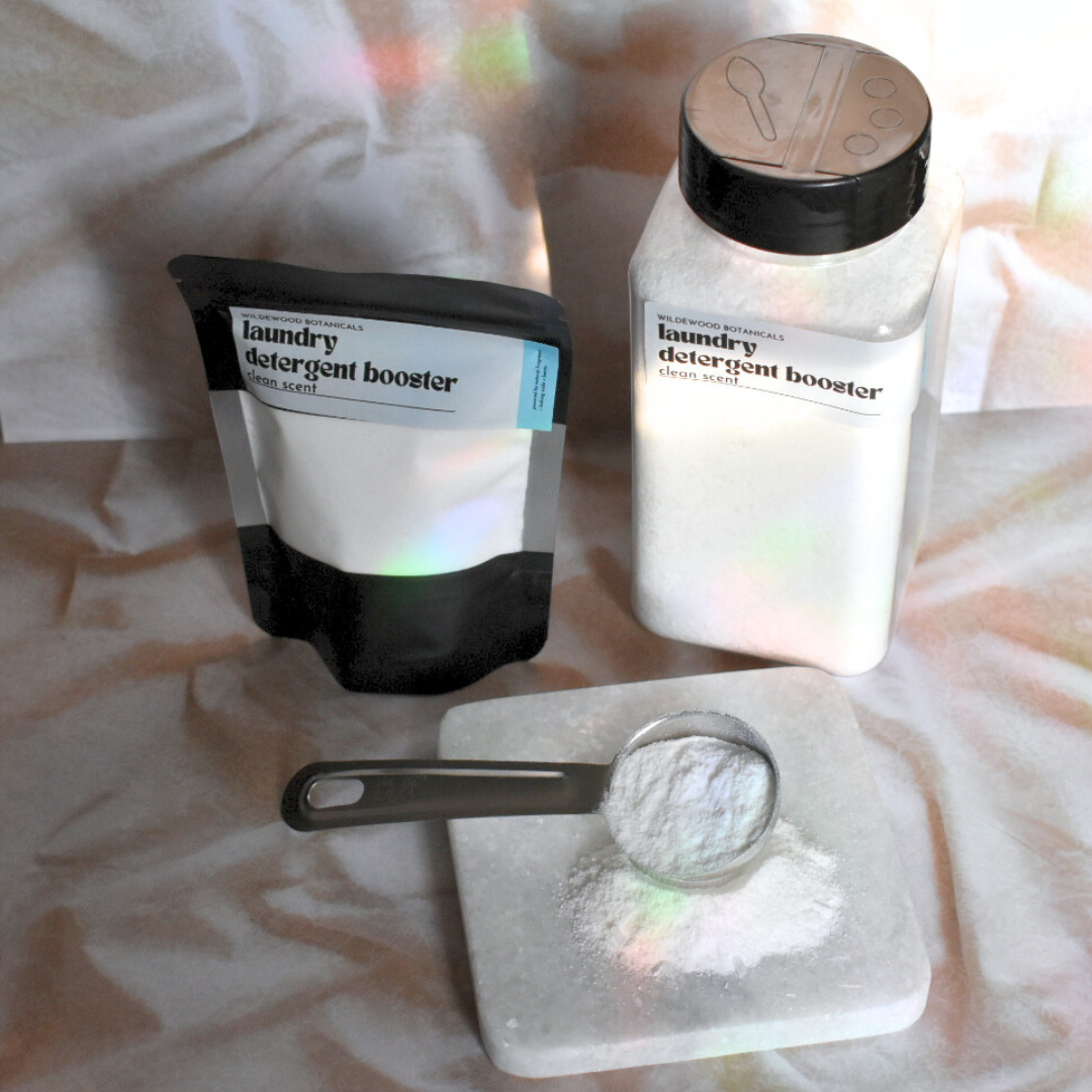 laundry detergent scent booster powder - clean scent in the sample and regular sizes on a flatlay with blanket texture