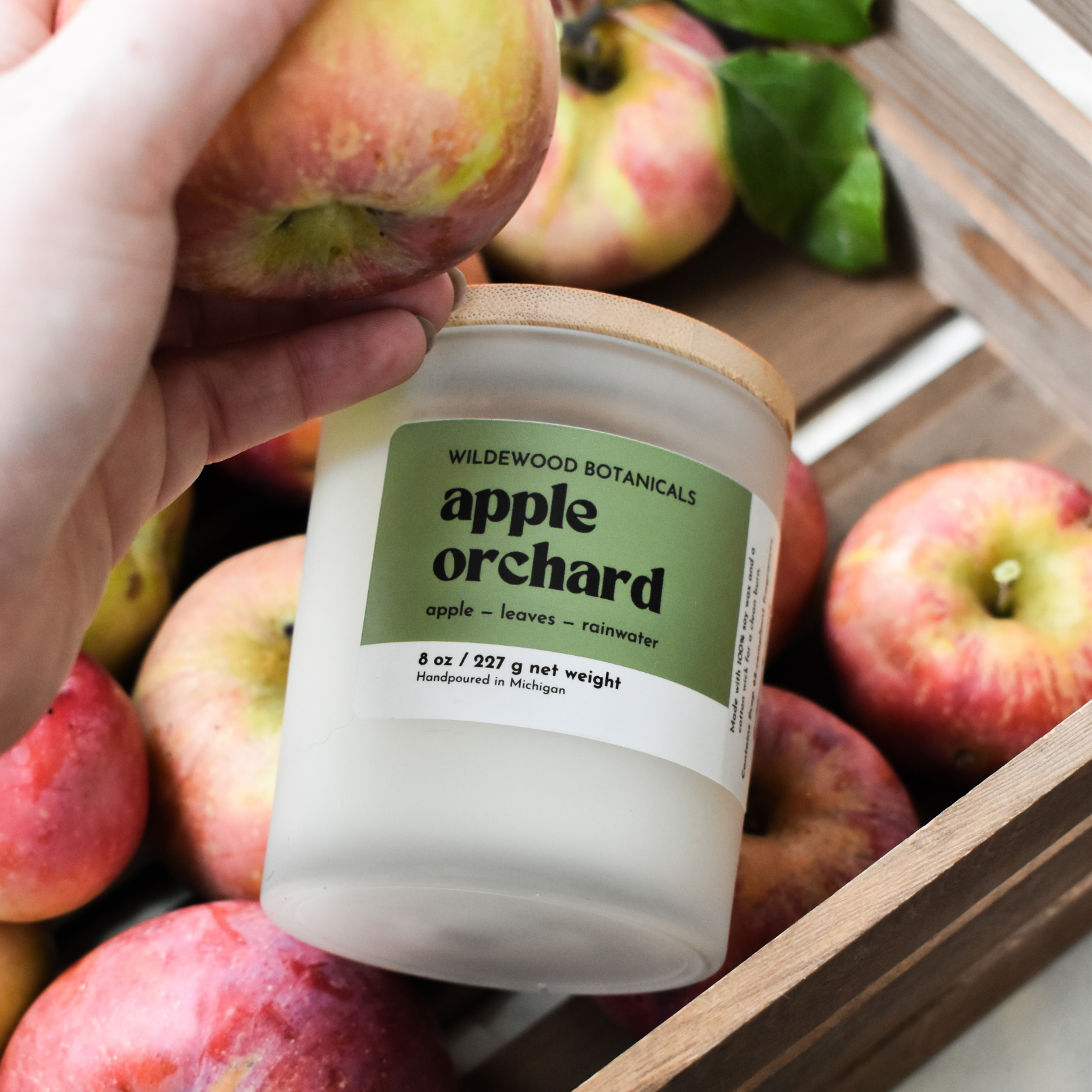 regular size apple orchard candle in a crate of apples