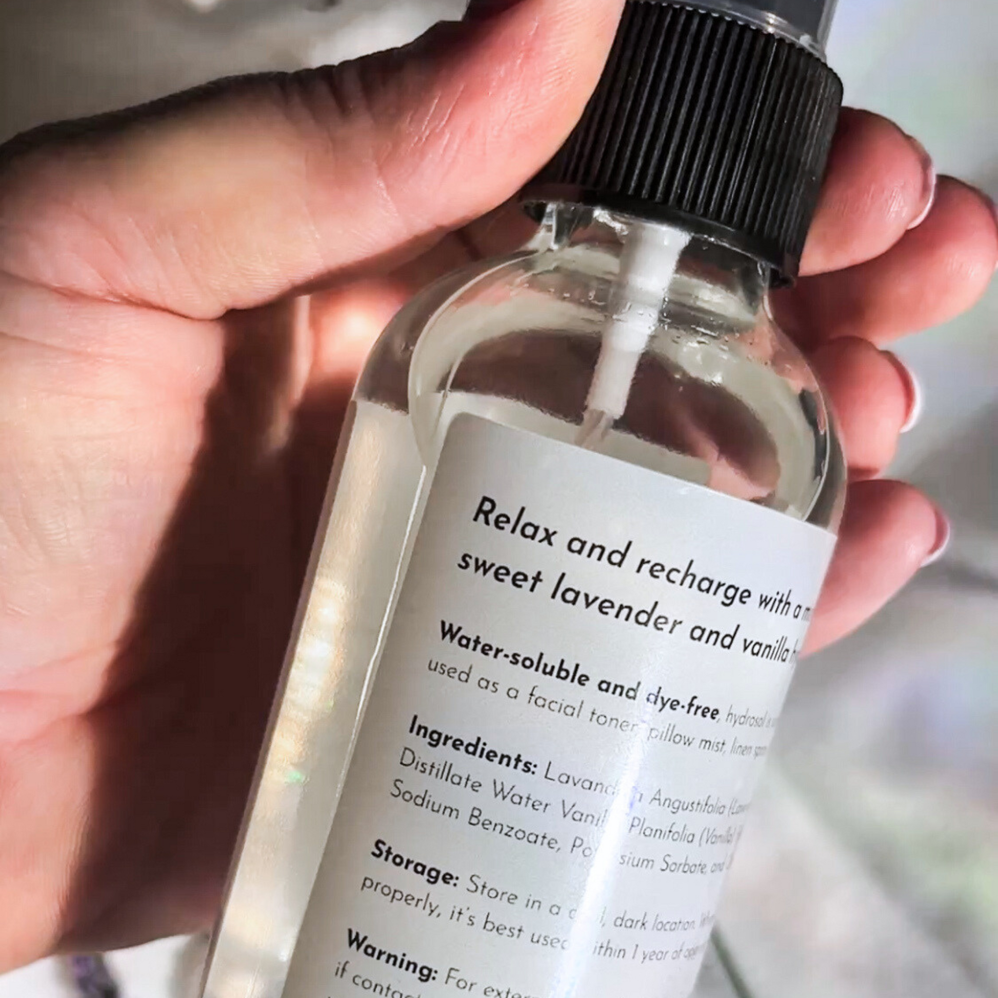 Hand holding a bottle of WIldewood Botanicals' Lavender Botanical mist with the ingredients label