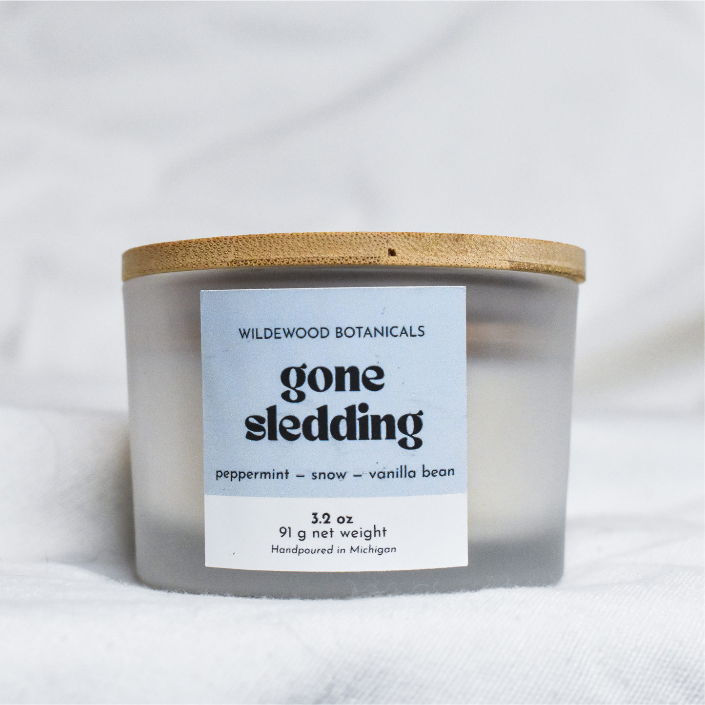 Mini Gone Sledding Soy Candle with a label on a white background.